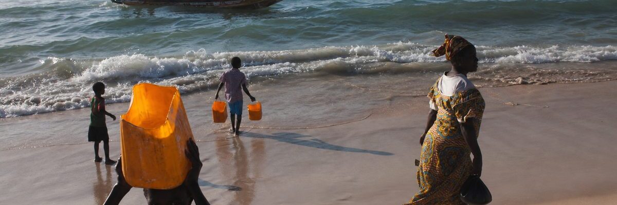 Plage de Guet Ndar sur la Langue de Barbarie à Saint-Louis du Sénégal, pirogue de pêche dans les vagues