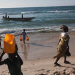 Plage de Guet Ndar sur la Langue de Barbarie à Saint-Louis du Sénégal, pirogue de pêche dans les vagues