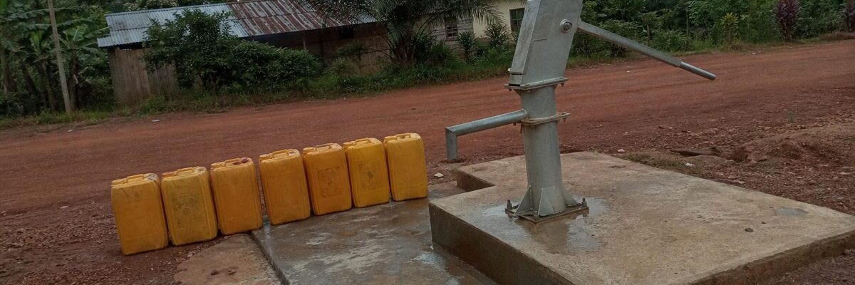 Pompe à main d'un forage d'eau potable au bord d'un chemin de latérite dans le Niari