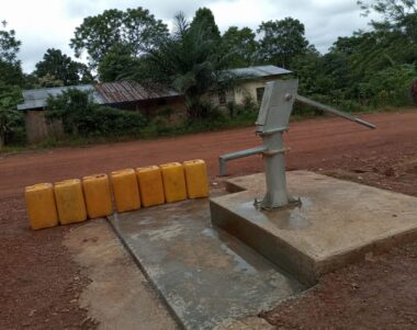 Pompe à main d'un forage d'eau potable au bord d'un chemin de latérite dans le Niari